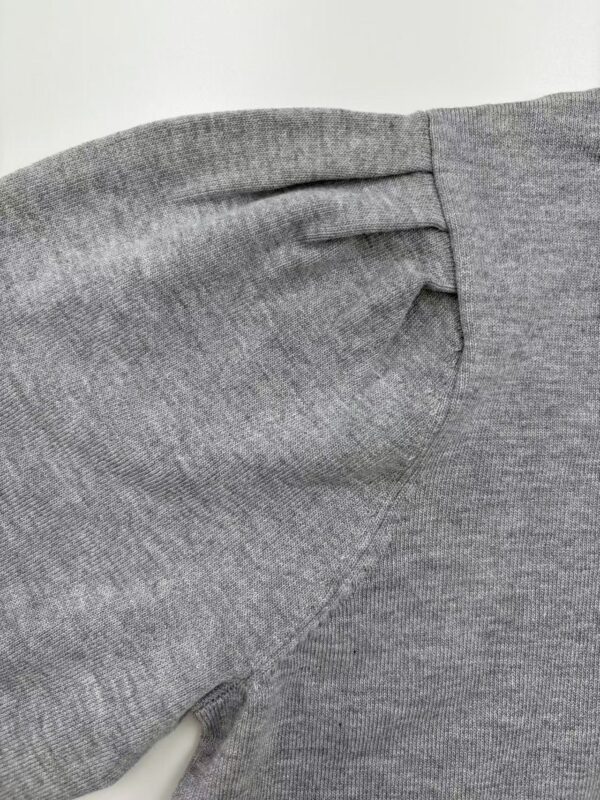 Close-up of a grey fabric sleeve showing detailed stitching and texture, ideal for fashion and clothing product images.