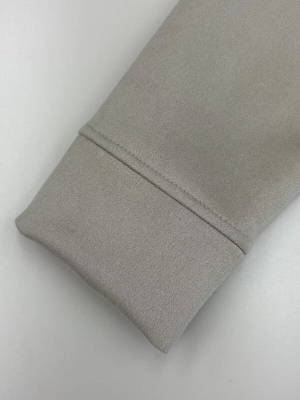 Close-up of a beige fabric sleeve with a clean seam, showcasing smooth texture and high-quality material, ideal for fashion or clothing design.