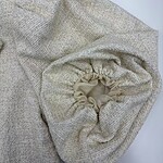 Close-up of a beige knitted sweater with a drawstring detail, showcasing soft textured fabric and stylish design for casual or chic wear.