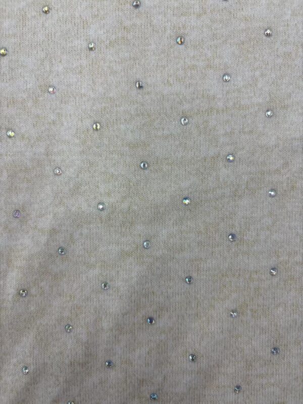 Close-up of beige fabric with small, shiny beads creating a subtle, elegant pattern, ideal for high-end fashion or accessories.