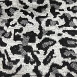Close-up of black and gray leopard print fabric, showcasing the detailed pattern and texture suitable for fashion and textile design.