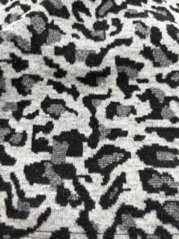 Close-up of black and gray leopard print fabric, showcasing the detailed pattern and texture suitable for fashion and textile design.
