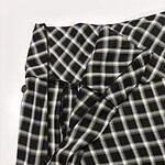 Close-up of black and white checkered fabric with a bow detail, suitable for fashion and clothing design.