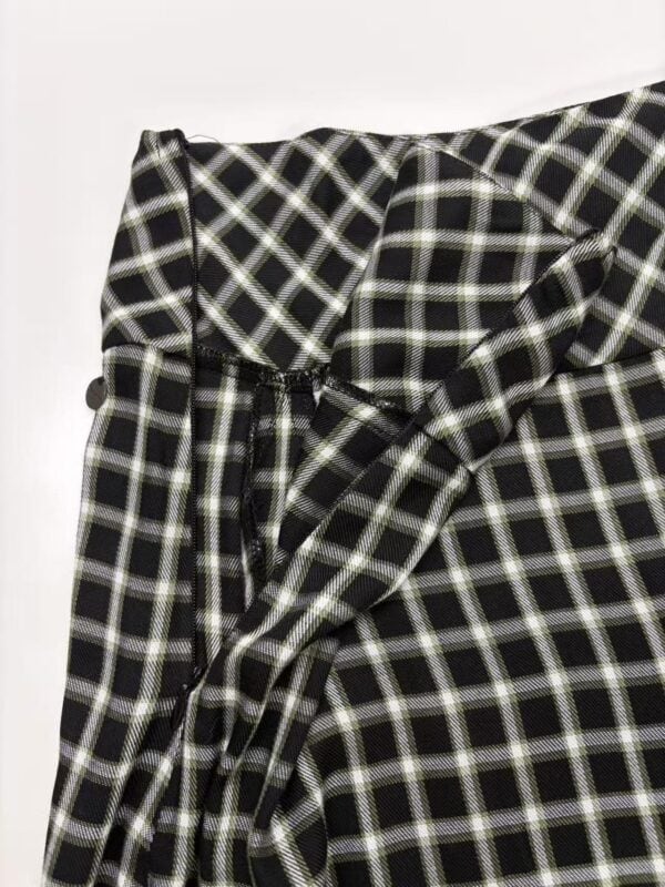 Close-up of black and white checkered fabric with a bow detail, suitable for fashion and clothing design.