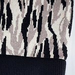 Close-up of a stylish knit beanie hat featuring a zebra print pattern in black and beige with a solid black ribbed brim, perfect for fashion and warmth.