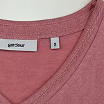 Close-up of pink V-neck T-shirt with Gardeur brand label and size S tag, showcasing soft fabric and stitching details.
