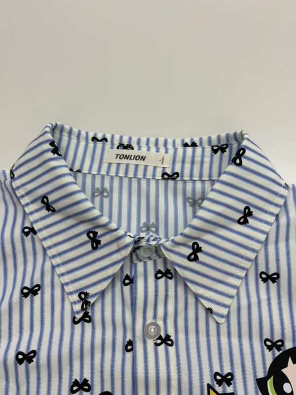 Close-up of a blue and white striped shirt with small black bow patterns, featuring a classic collar and button-down front, perfect for casual or office wear.