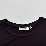 Close-up of a black T-shirt featuring a gold geometric pattern on the front, with a round neckline and a size M label from Broadway.