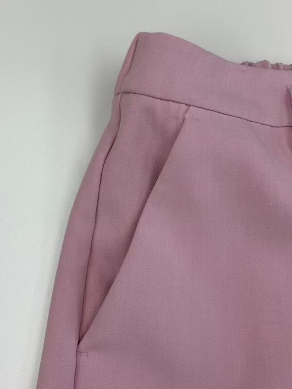 Close-up of pink women's pants with a tailored fit, featuring a side pocket and smooth fabric, perfect for casual or semi-formal wear.