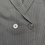 Close-up of a gray pinstripe suit jacket with two buttons and a notched lapel, showcasing professional men's fashion.