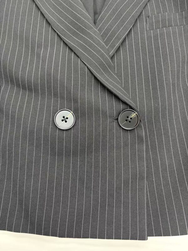 Close-up of a gray pinstripe suit jacket with two buttons and a notched lapel, showcasing professional men's fashion.