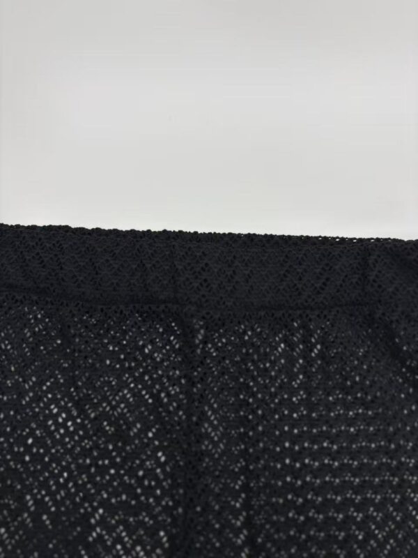 Detailed close-up of black lace fabric with intricate pattern, suitable for fashion and clothing design.