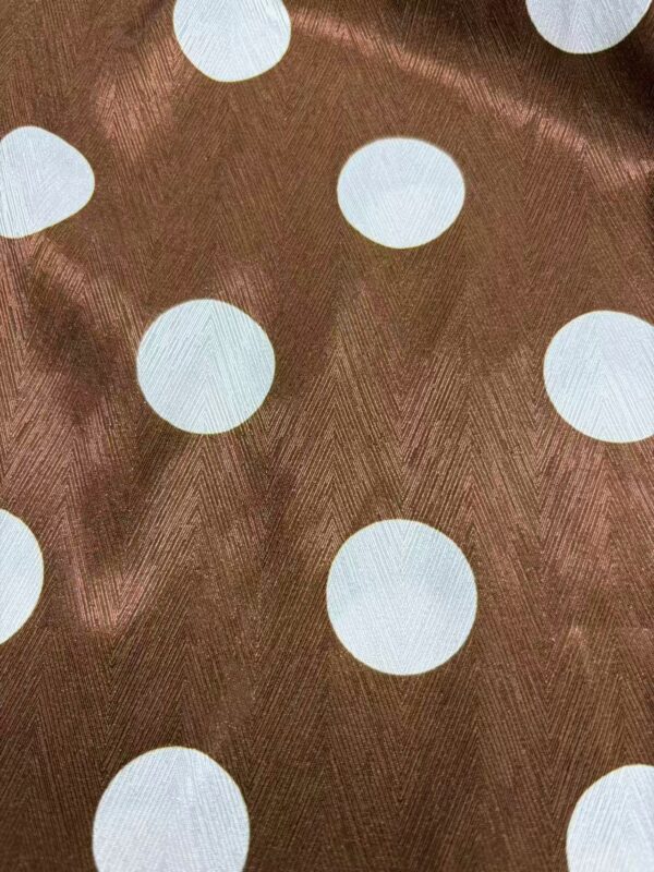 Close-up of brown fabric with white polka dots, suitable for fashion and clothing design projects.