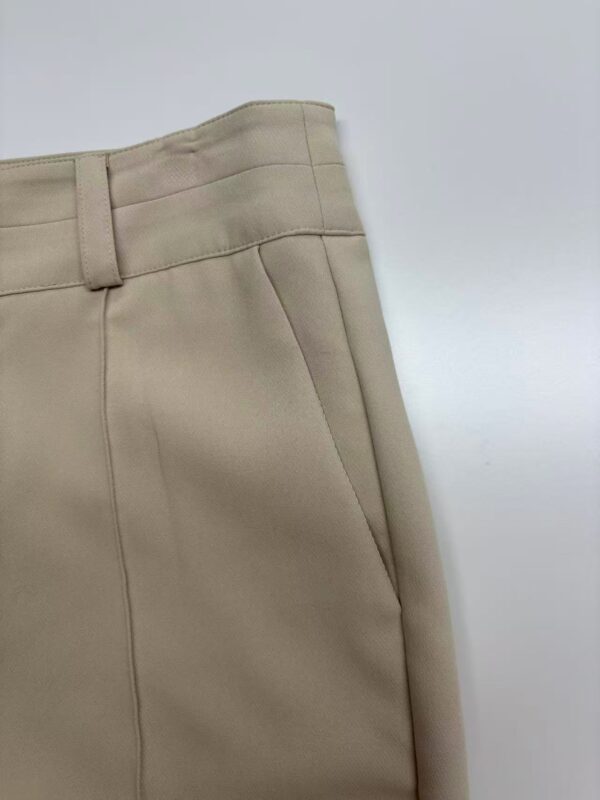 Close-up of beige women's trousers showing tailored fit and high-quality fabric, ideal for professional or casual wear.