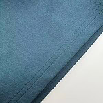 Detailed close-up of blue fabric material with visible stitching, suitable for fashion or textile product descriptions.