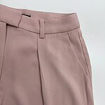 Close-up of stylish pink women's trousers with tailored fit and belt loops, perfect for office or casual wear.