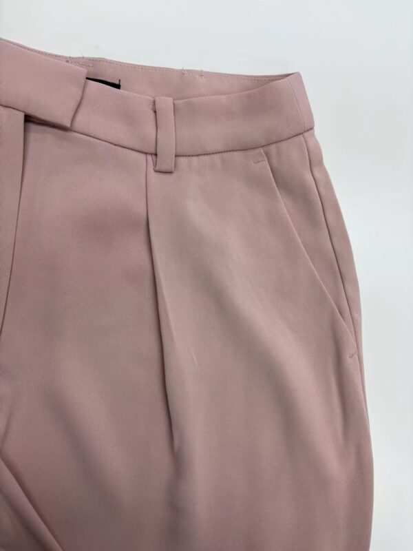 Close-up of stylish pink women's trousers with tailored fit and belt loops, perfect for office or casual wear.