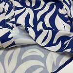 Close-up of a stylish blue and white animal print shirt with button details, perfect for casual or trendy fashion looks.