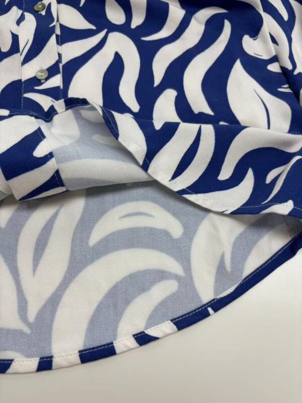 Close-up of a stylish blue and white animal print shirt with button details, perfect for casual or trendy fashion looks.