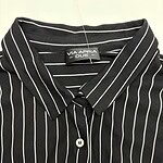 Men's black shirt with white vertical pinstripes, classic collar, and button-down front, suitable for formal or business casual wear.