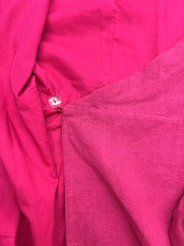 Close-up of vibrant pink fabric showcasing texture and stitching details, ideal for fashion and clothing design.