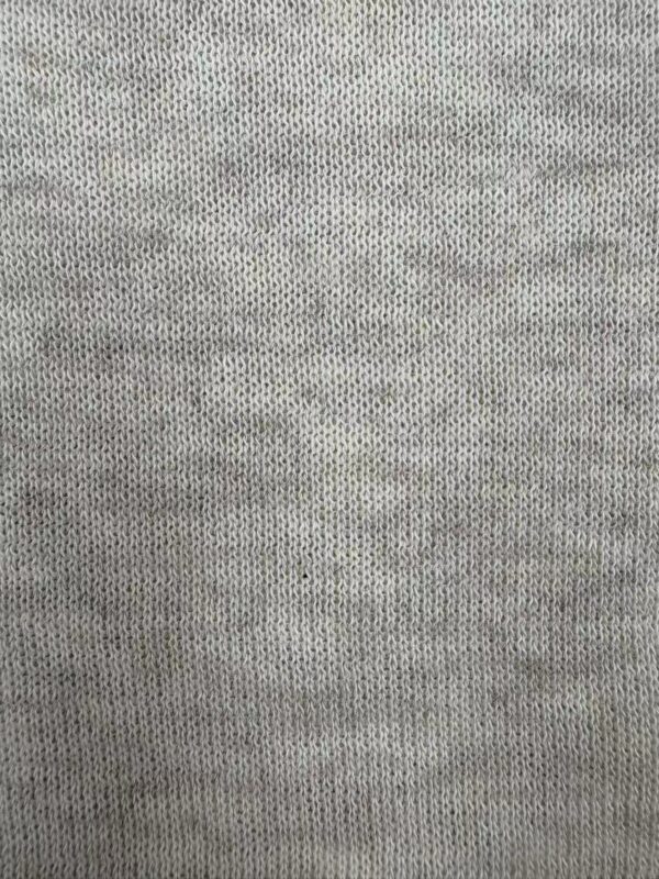 Detailed close-up of light gray knit fabric showing fine stitches and texture, ideal for fashion and textile design.