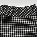 Close-up of a black and white checkered skirt with a high waist, showcasing a classic pattern suitable for casual or office wear.