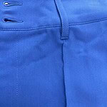 Close-up of vibrant blue men's fashion pants showing waistband and stitching details.