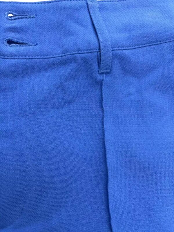 Close-up of vibrant blue men's fashion pants showing waistband and stitching details.