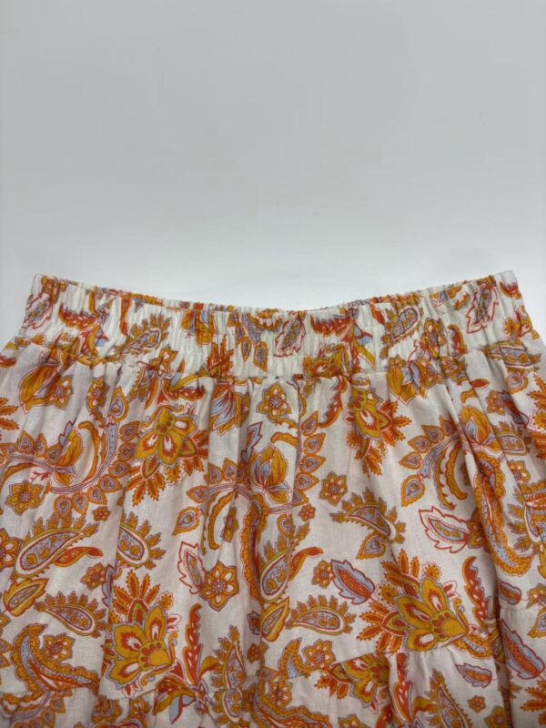 Colorful bohemian style skirt with orange, yellow, and pink paisley and floral patterns, elastic waistband, perfect for casual summer wear.