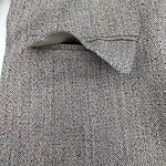 Close-up of a classic herringbone wool coat with a tailored pocket detail, showcasing high-quality fabric and craftsmanship for stylish winter wear.
