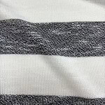 Close-up of a fabric with alternating black and white horizontal stripes, showcasing the texture and weave of the material.