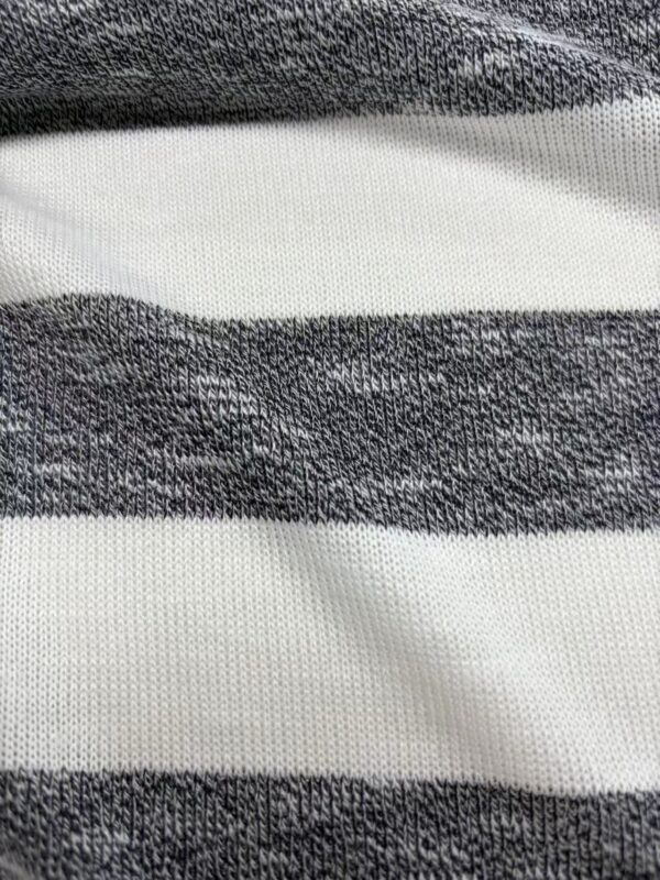 Close-up of a fabric with alternating black and white horizontal stripes, showcasing the texture and weave of the material.