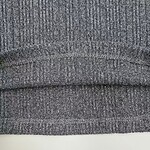 Detailed close-up of grey fabric with fine texture, suitable for clothing or upholstery, showcasing the weave pattern and fabric quality.