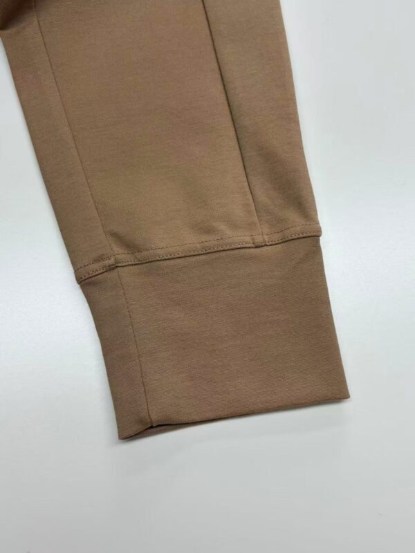 Close-up of beige sweatpants cuff showing soft fabric and stitching, ideal for casual and athleisure wear.