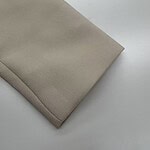 Close-up of beige fabric with folded edge, suitable for fashion or upholstery projects.
