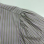 Close-up of striped fabric with purple, green, and white lines, showcasing detailed stitching and texture for fashion design.
