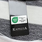 Close-up of Kapalua XXII clothing tag showing size and brand details on a striped fabric background.