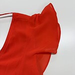 Close-up of a vibrant red dress with ruffle details, perfect for stylish occasions and fashion statements.
