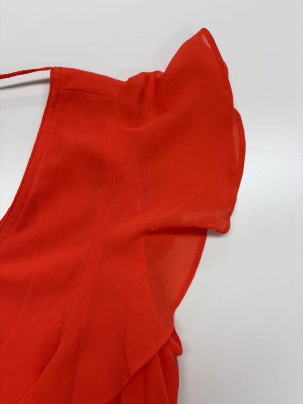 Close-up of a vibrant red dress with ruffle details, perfect for stylish occasions and fashion statements.