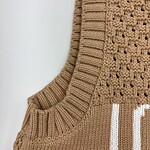 Close-up of a beige knitted sweater with intricate patterns and ribbed collar, perfect for fall fashion and cozy wear.
