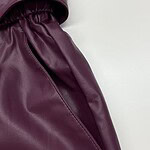 Close-up of a stylish burgundy leather skirt with a high waist and smooth texture, perfect for fashionable women's wardrobe.