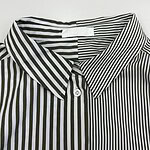 Close-up of a black and white vertically striped dress shirt with a classic collar and button-down front, suitable for formal or office wear.