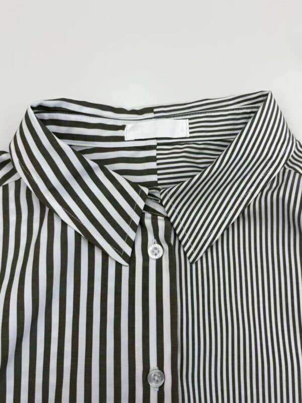Close-up of a black and white vertically striped dress shirt with a classic collar and button-down front, suitable for formal or office wear.
