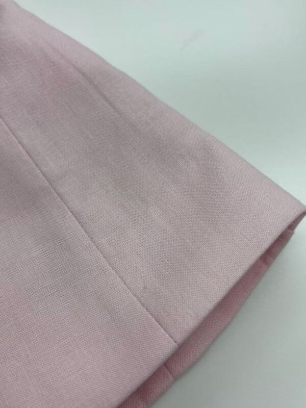Close-up of soft pink fabric with smooth texture, ideal for fashion and clothing design projects.