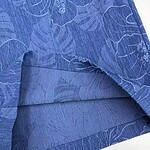 Close-up of blue linen fabric with floral pattern, ideal for stylish clothing and accessories.