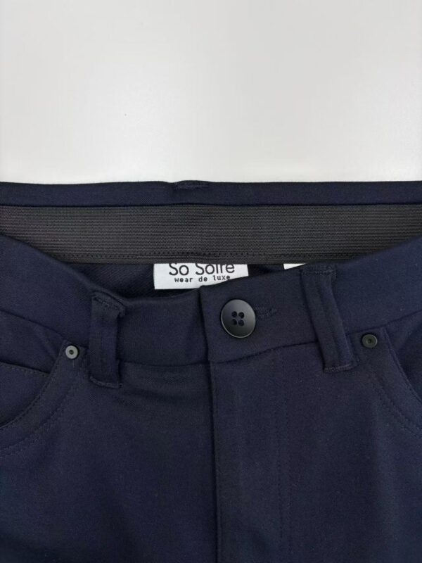 Close-up of navy blue women's trousers with button and zipper closure, showcasing a sleek and professional style suitable for office wear or formal occasions.