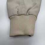 Close-up of a beige hoodie sleeve showing fabric texture and ribbed cuff, ideal for casual fashion and streetwear styles.