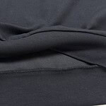 Close-up image of black fabric material showing texture and stitching details, suitable for fashion or clothing product descriptions.