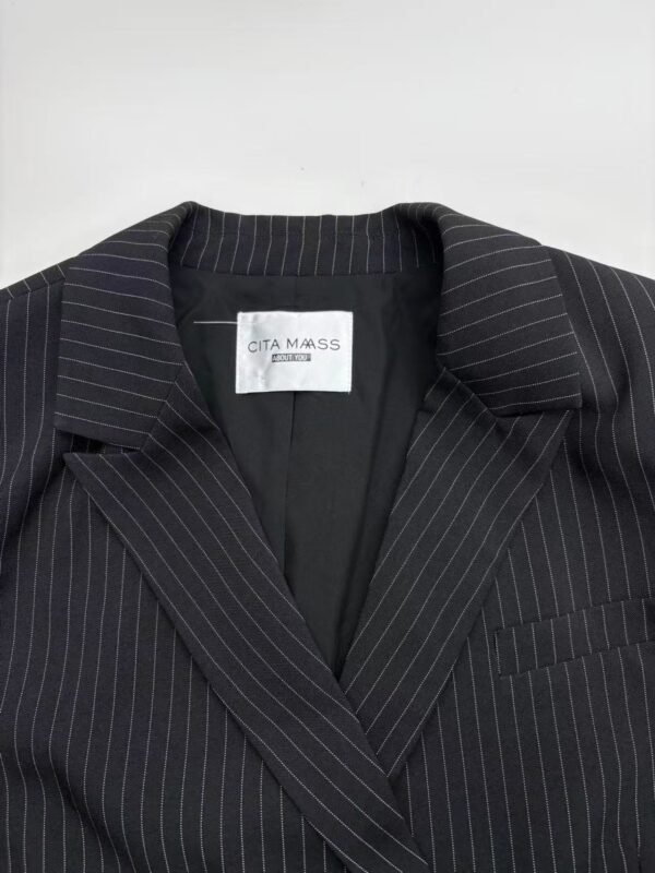 Close-up of a black pinstripe suit jacket with a notched lapel, tailored fit, and subtle white pinstripes, perfect for professional or formal occasions.